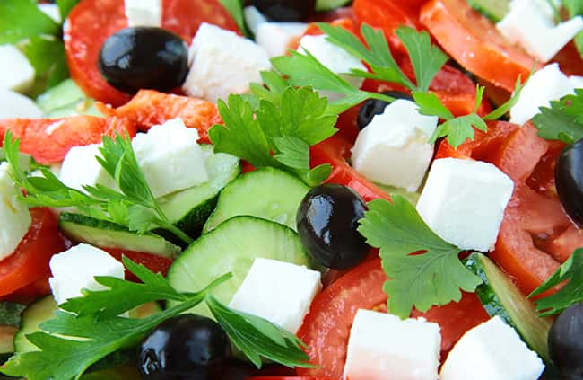 Fresh garden salad with cucumbers, black olives, cheese, tomatoes.