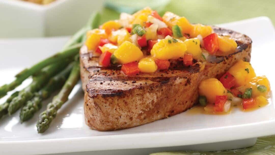 piece of meat with asparagus and mango salsa