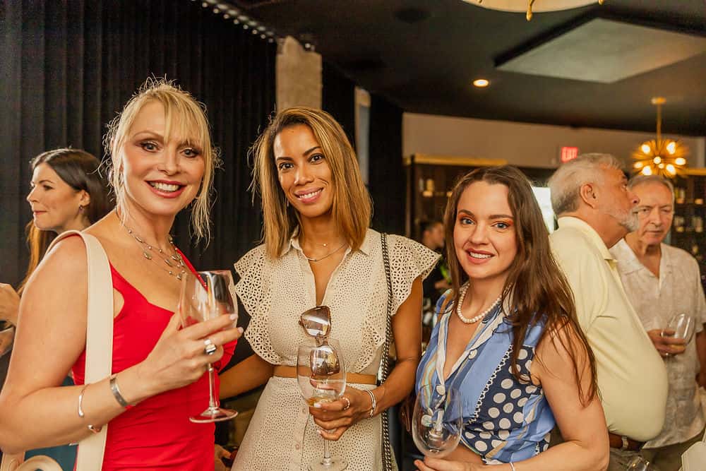 Women wearing polished upscale attire while dining and socializing at a Coral Gables restaurant.