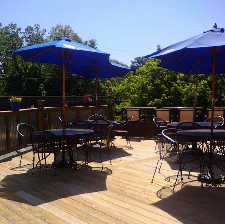Outside patio area with tables and chairs with open blue umbrellas