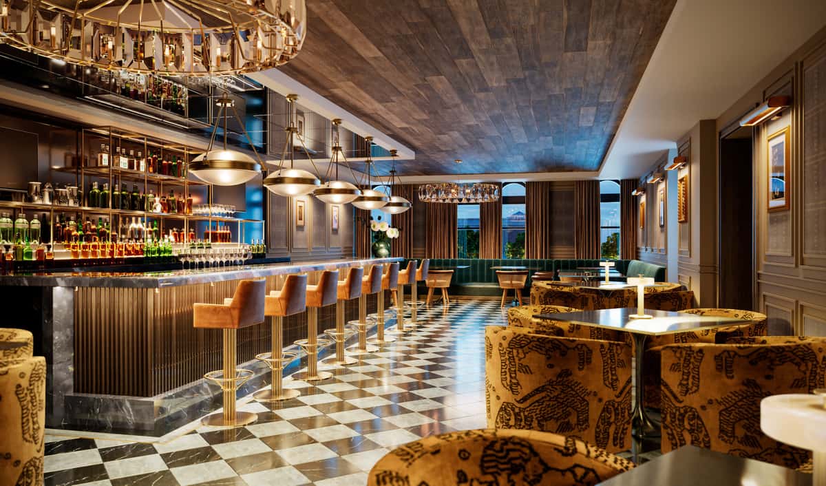 Luxurious bar interior with checkered flooring, a long marble-topped bar, tan leather barstools, and patterned armchairs around tables.
