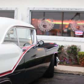 vintage car parked outside of the carol stream location