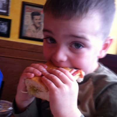 little boy biting into a sandwich
