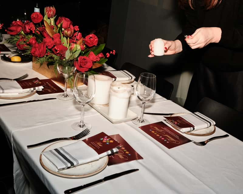 Table set for event with vase of red flowers