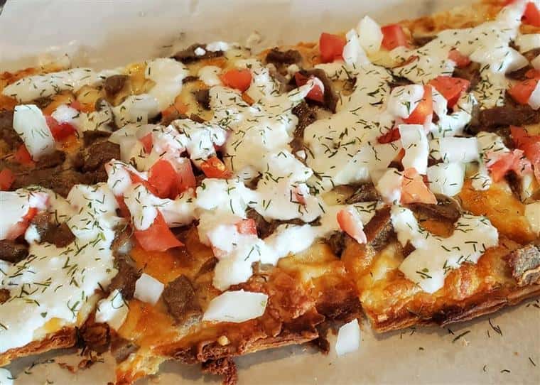 Nachos Grande: A mound of fresh frilled tortilla chips smothered with shredded cheese blend, tomatoes, jalapeños and beef