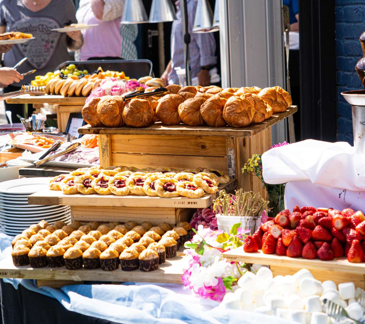 Abundant brunch buffet featuring freshly baked pastries, croissants, muffins and seasonal strawberries, creating an inviting spread for private events, catering and weekend dining.