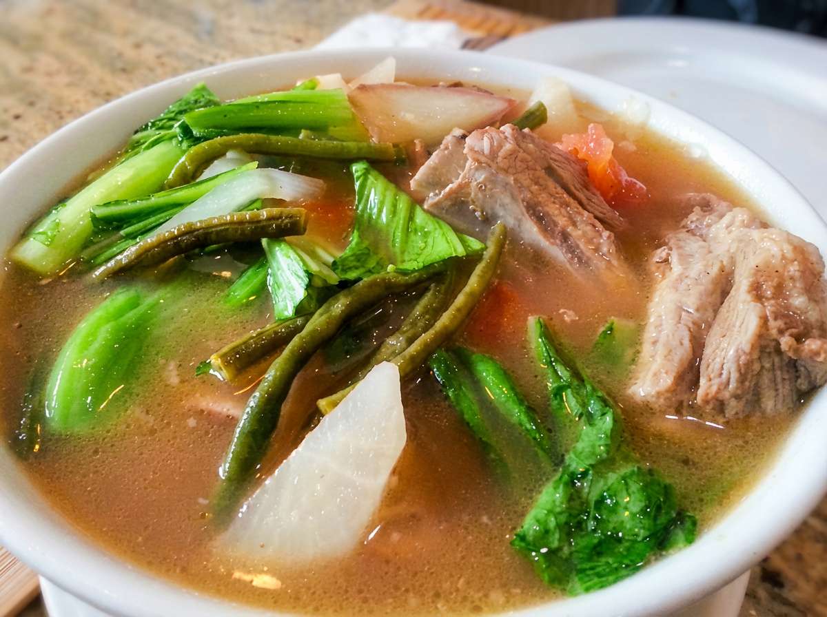 A comforting Filipino sour soup with tender pork and fresh vegetables in a rich tamarind broth.