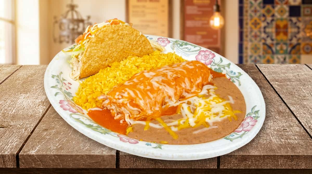 A classic Mexican combo plate with a burrito covered in sauce and melted cheese, served alongside rice and beans. The dish is simple, satisfying, and full of traditional flavor.