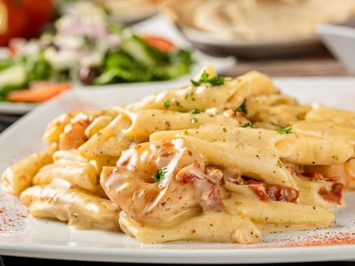 Creamy penne pasta with chicken, tomatoes, and herbs.