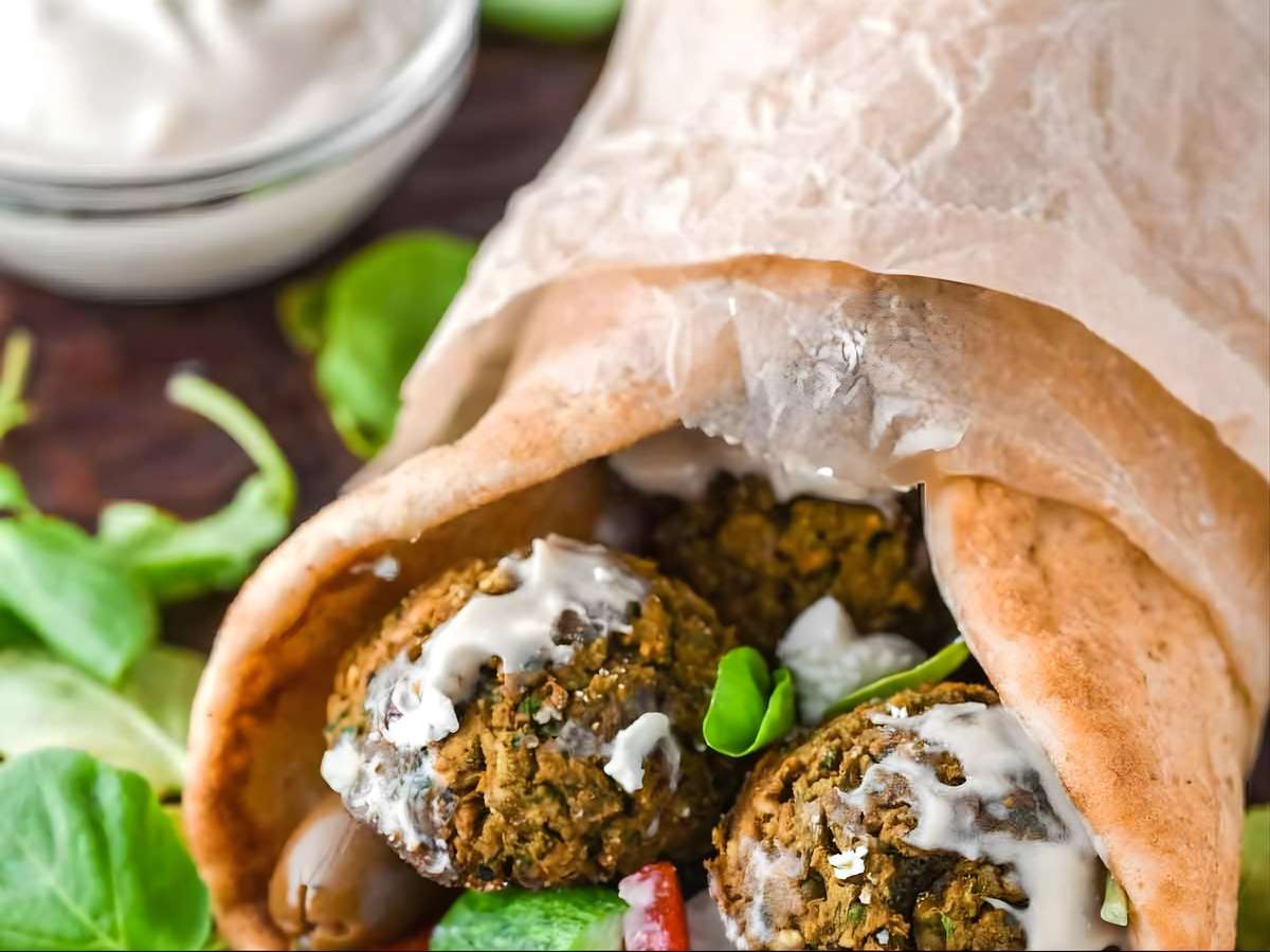 Falafel pita stuffed with fresh greens, vegetables, and creamy sauce.