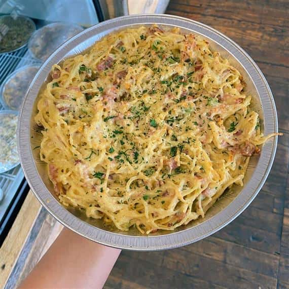 bowl of seafood scampi topped with parsley flakes and parmesan cheese
