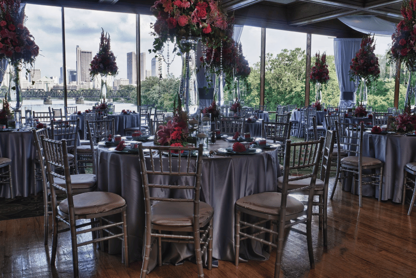 Exquisite private event spaces with plated tables with gray linens and seasonal red flowers