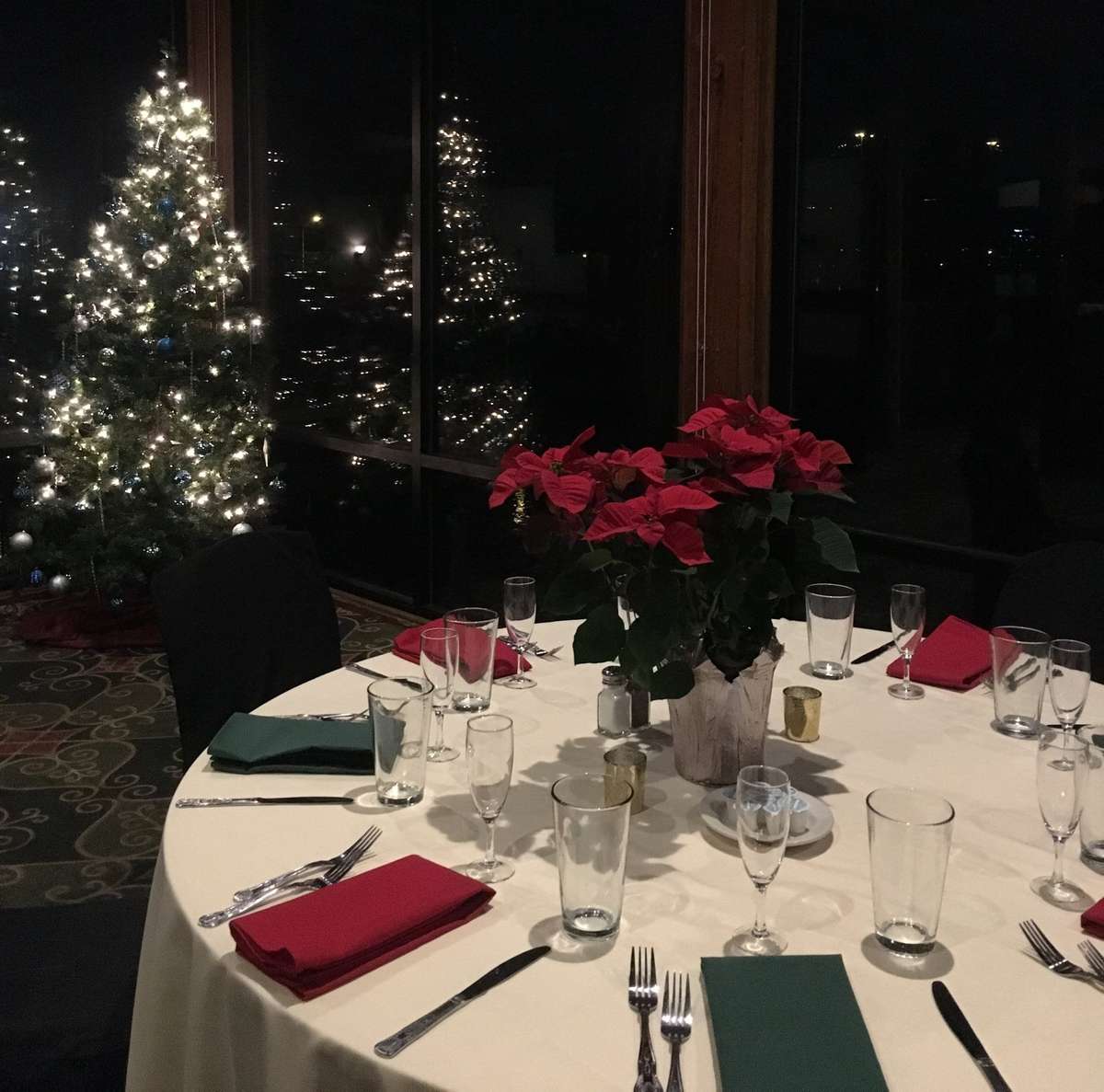 Festive atmosphere in the Olentangy Room with a beautifully lit Christmas tree and tables set with red napkins, inviting guests to a holiday celebration.