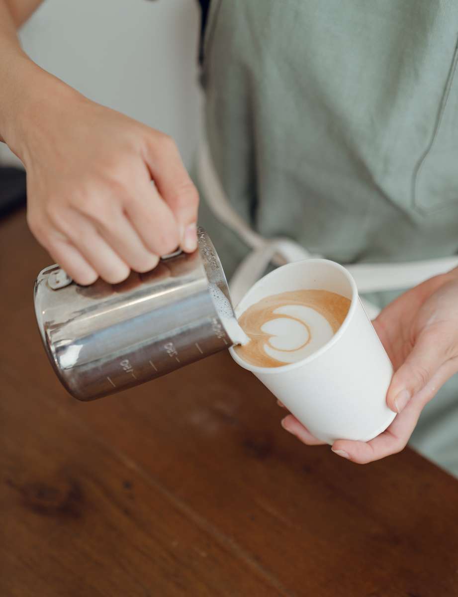 barista pouring coffee and milk