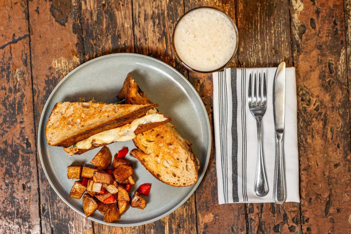 grilled cheese and beverage on rustic table