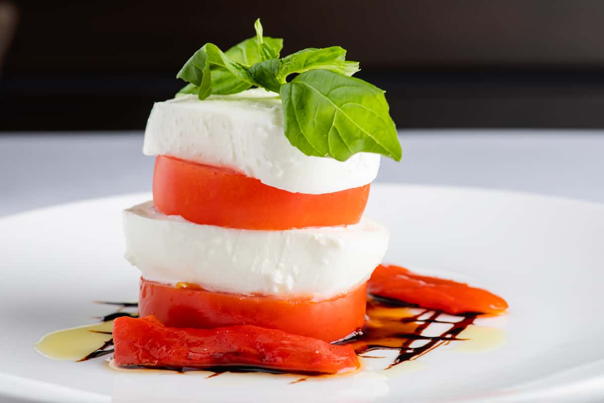 Homemade buffalo mozzarella served with roasted peppers, beefsteak tomatoes, basil, and olive oil