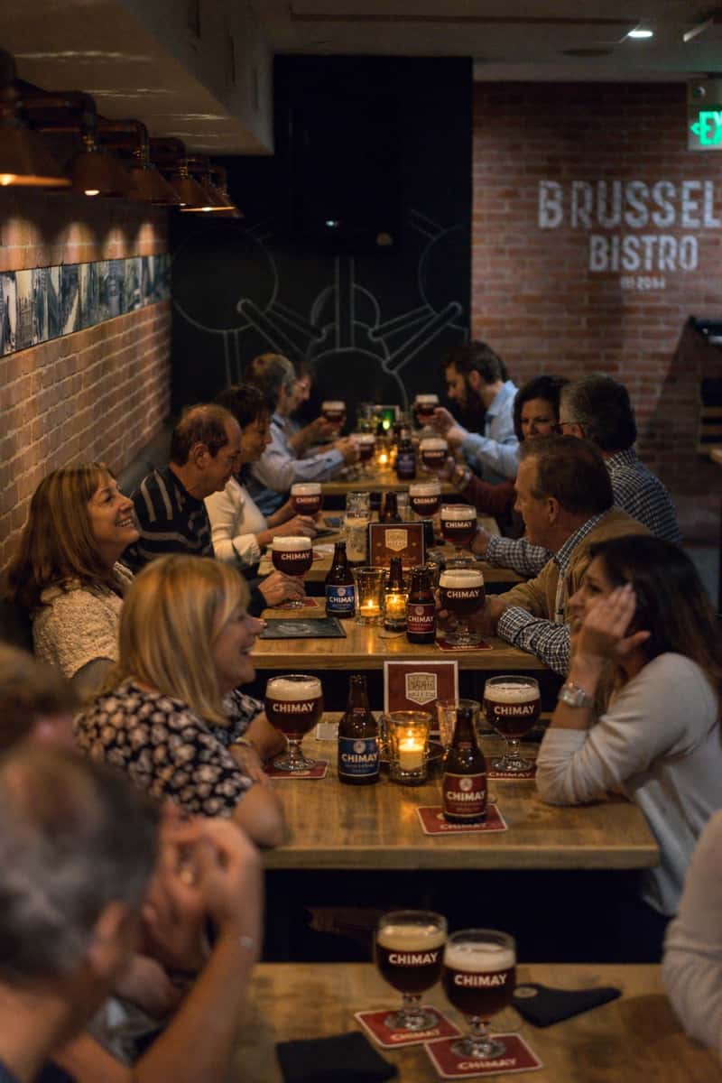 restaurant's guests enjoying Chimay beer at the table.