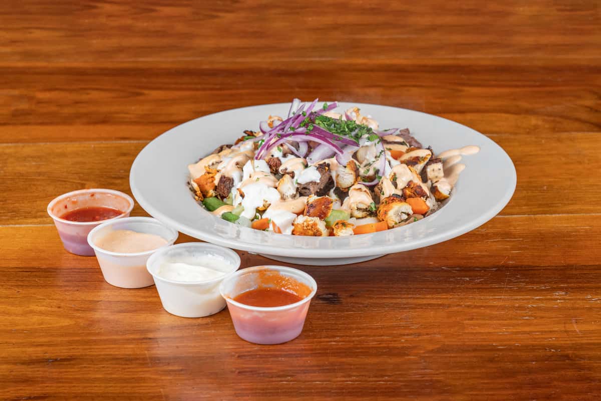 Fresh Mediterranean-style bowl with grilled chicken, vegetables, feta, and creamy sauce.