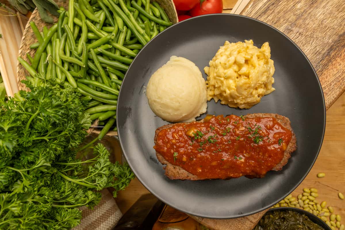 Meatloaf with a side of mashed potatoes and macaroni and cheese