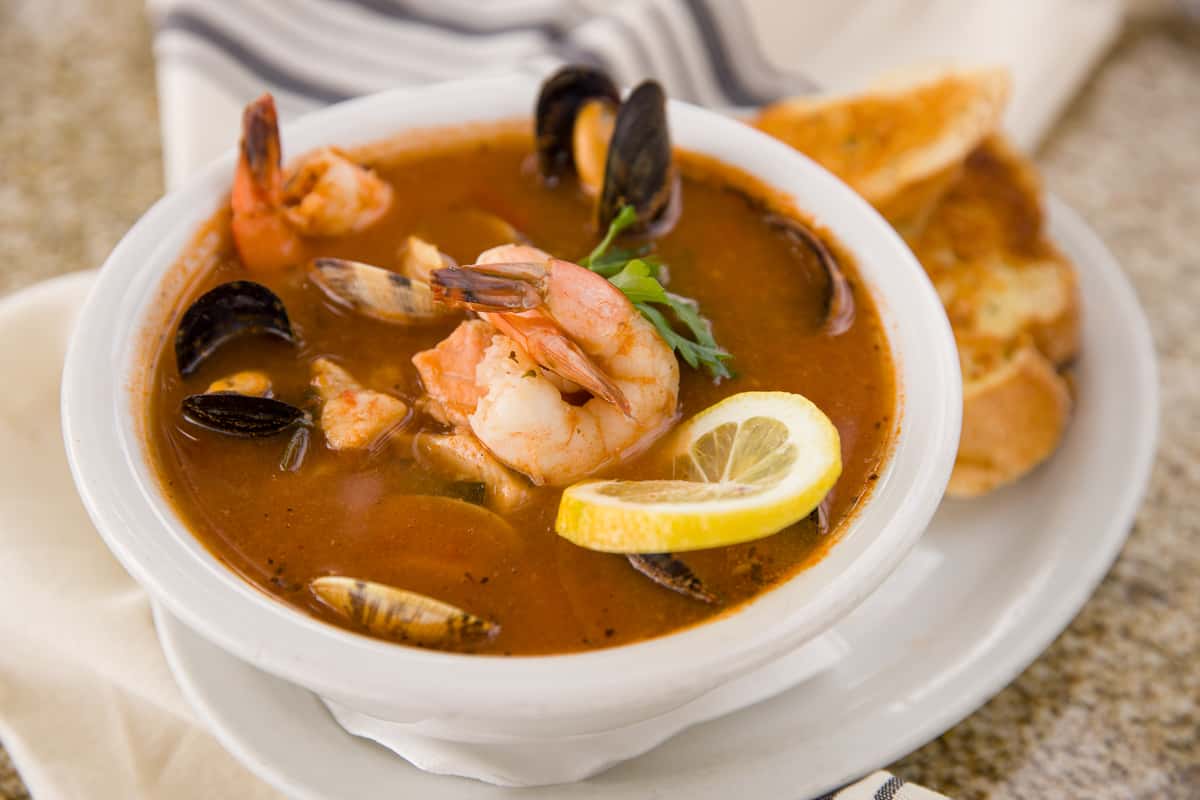 A hearty tomato stock with a selection of fresh fish and shellfish, served with garlic bread