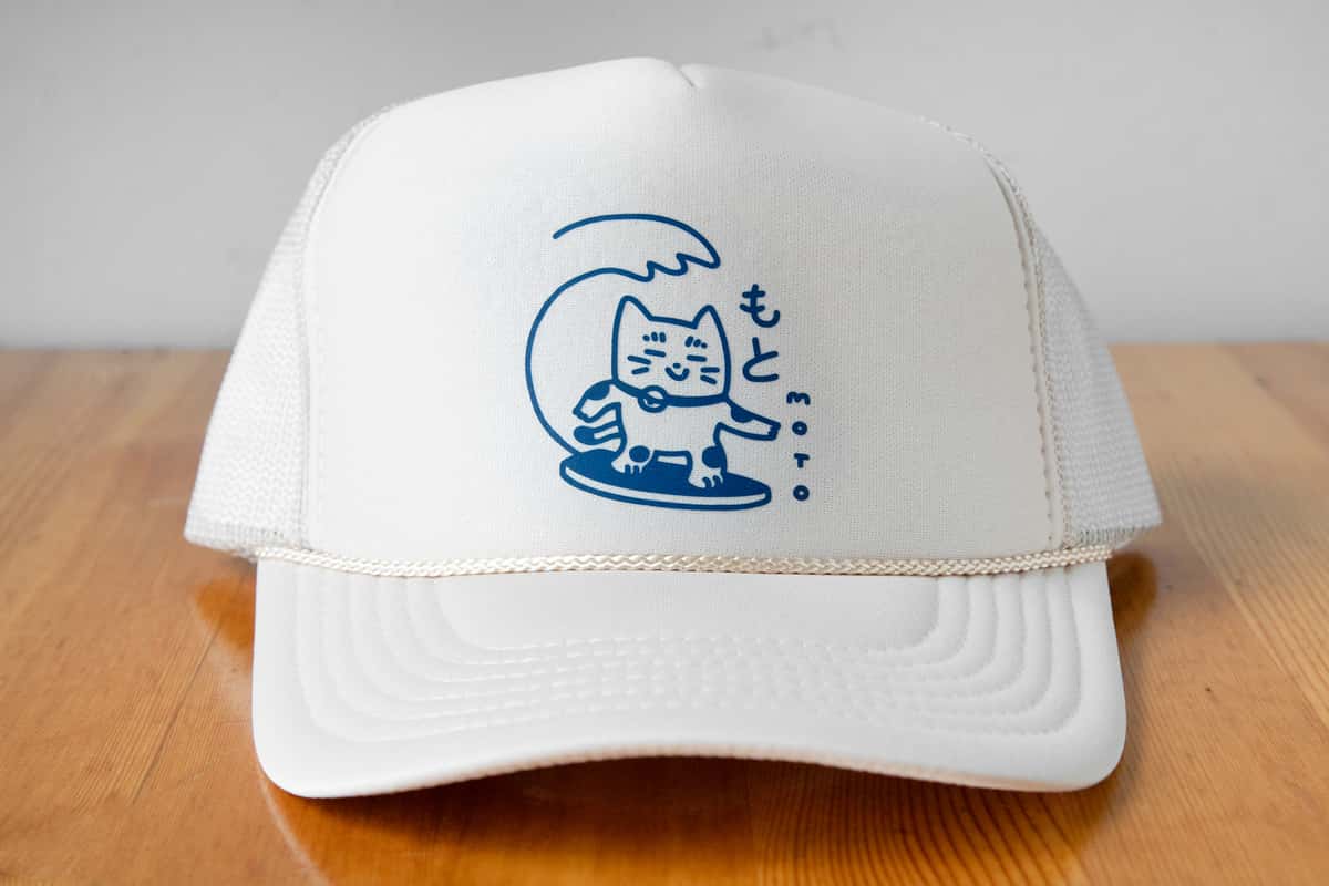 Closeup of a white hat with a blue embroidered graphic