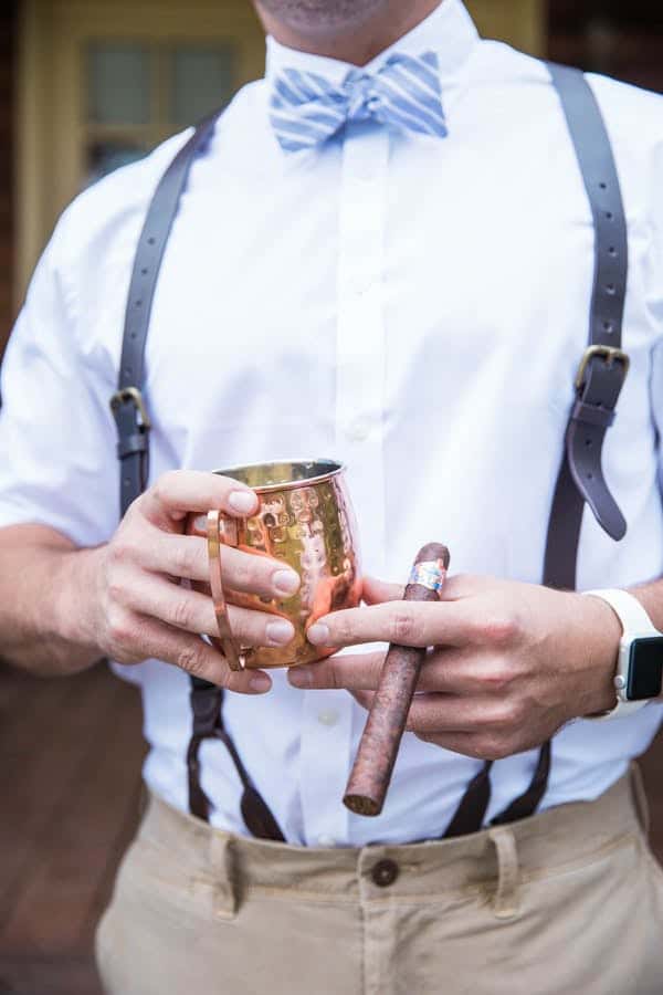 groomsman holding cup and a cigar