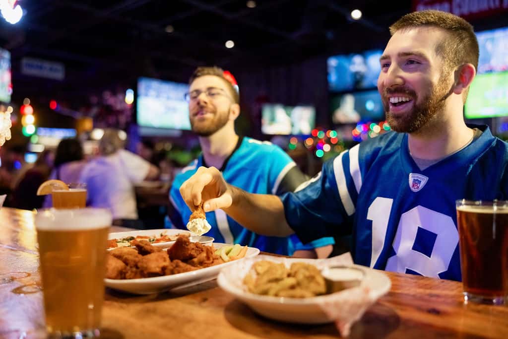 Group of men in football jerseys eating