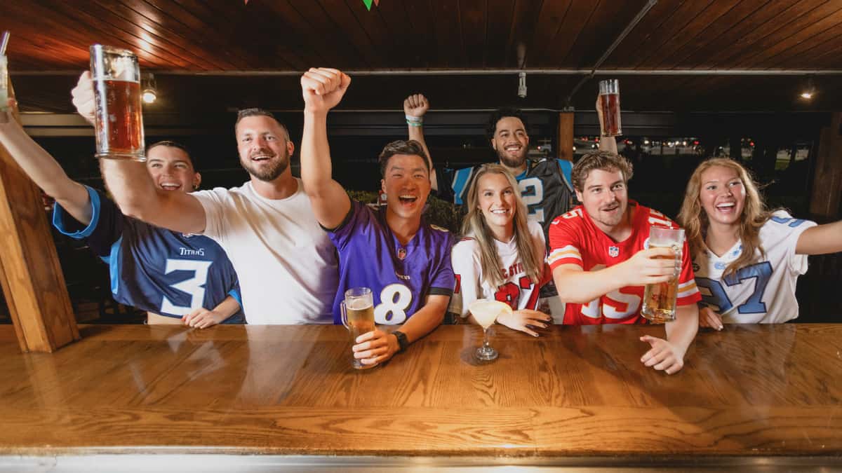 Group of NFL football fans cheering at Carolina Ale House