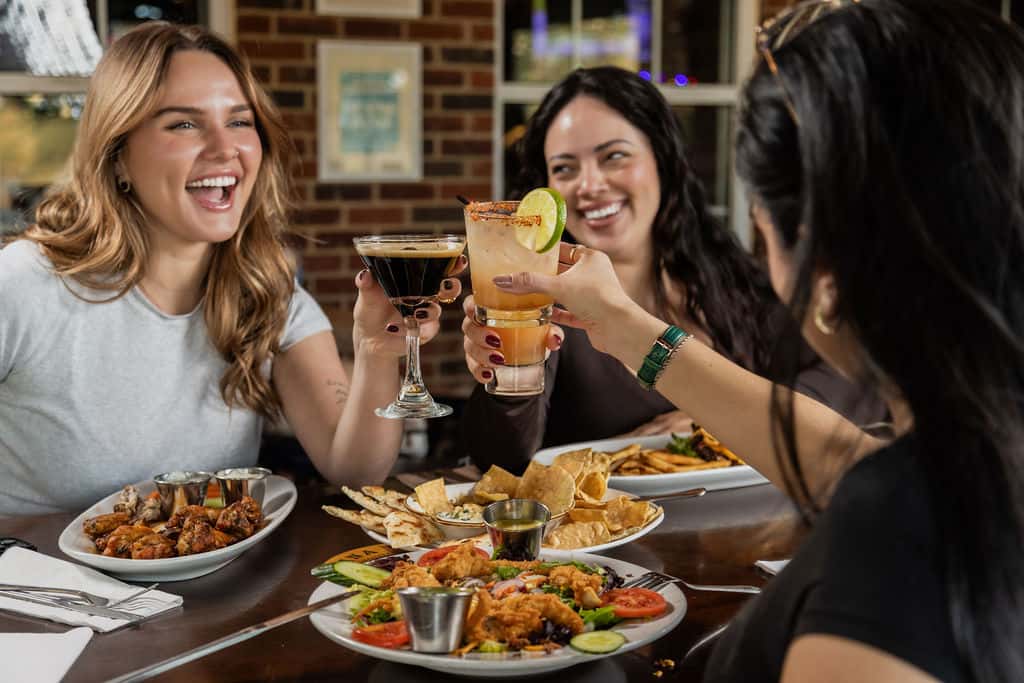 Women enjoying cocktails and food at Carolina Ale House