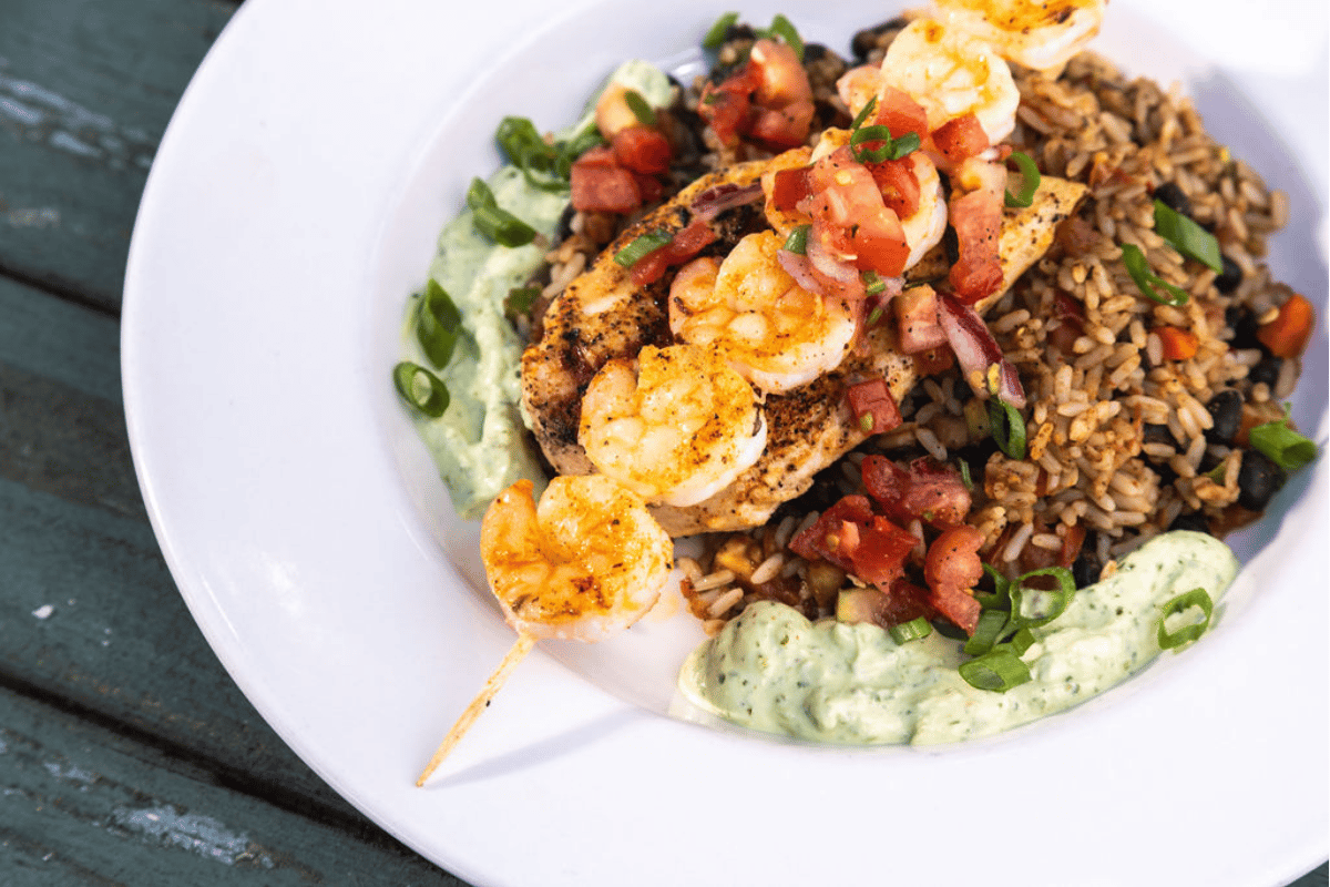 Bowl of food with shrimp and chicken on a bed of rice