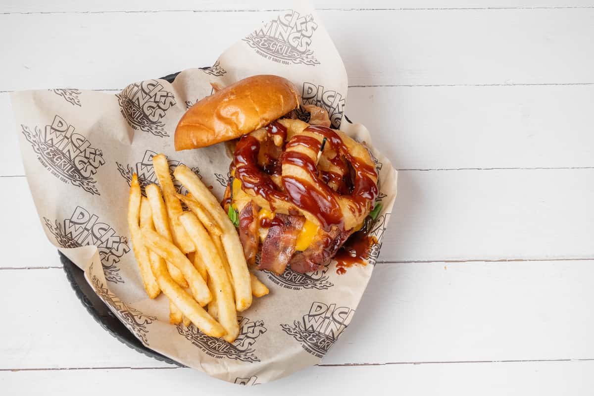 Top down view of BBQ burger with fries on a takeout basket