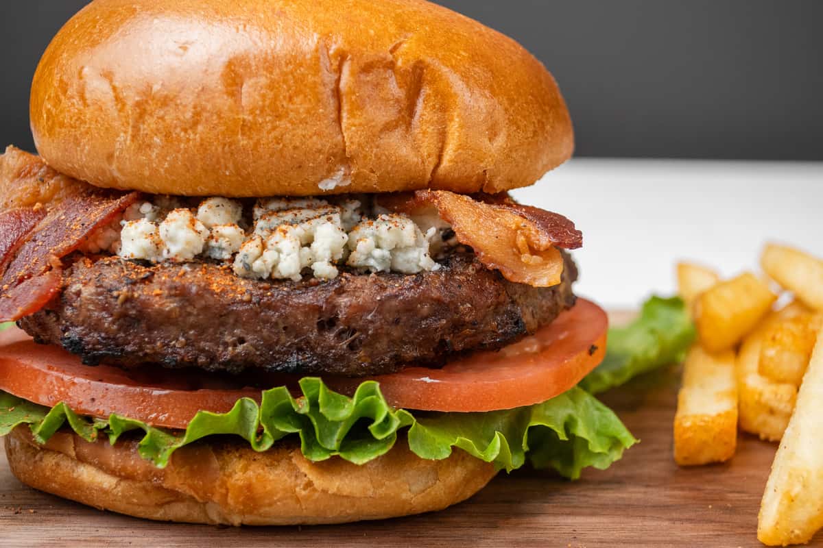 Close up shot of Black & Bleu Burger on a wooden tray