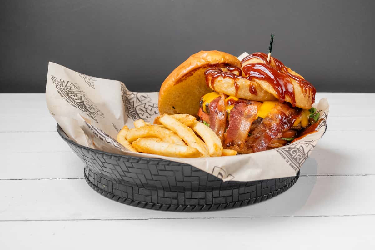Side view of a BBQ Burger in a basket with fries