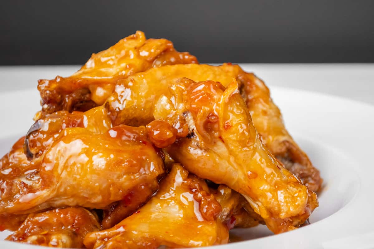 A pile of traditional wings on a white plate