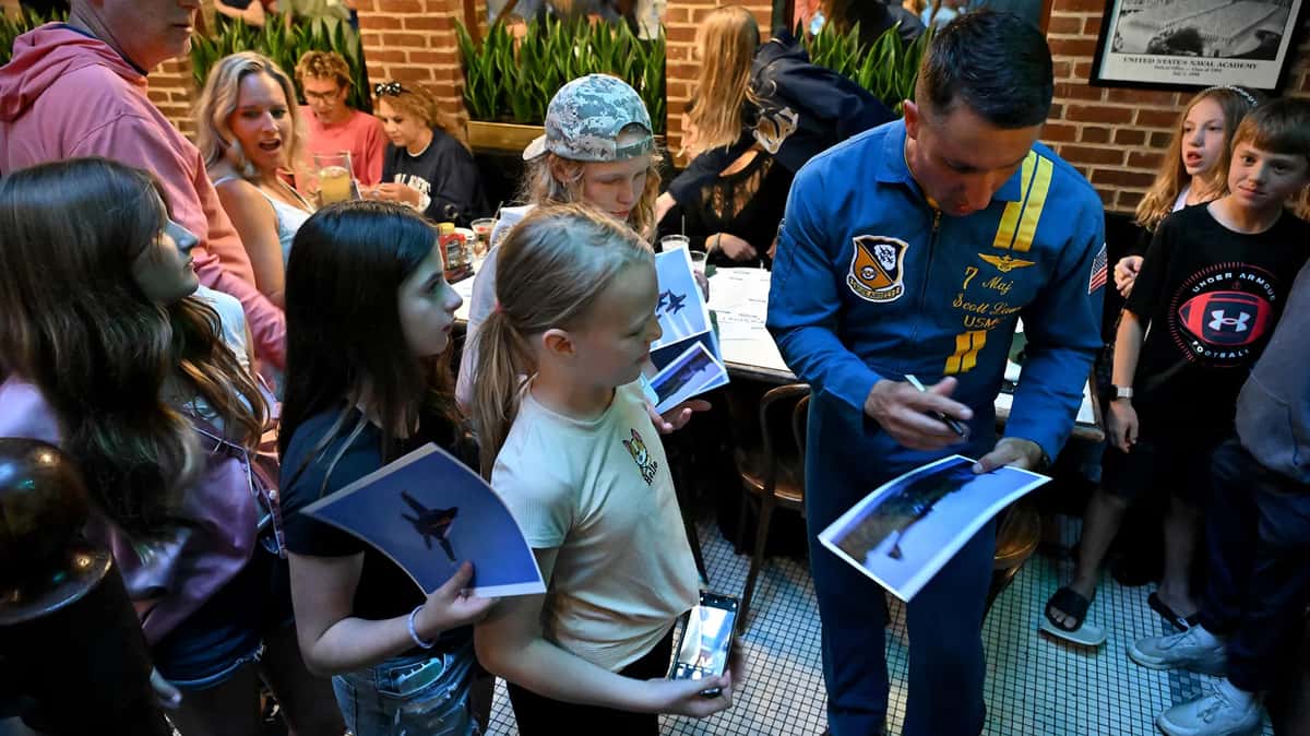 A Blue Angel signs pictures for children