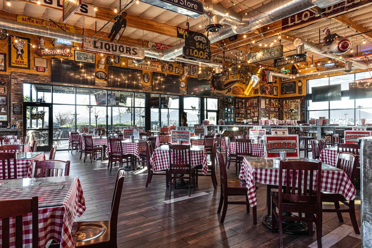 rustic restaurant dining room with checkered tablecloths, warm string lights, and spacious casual seating
