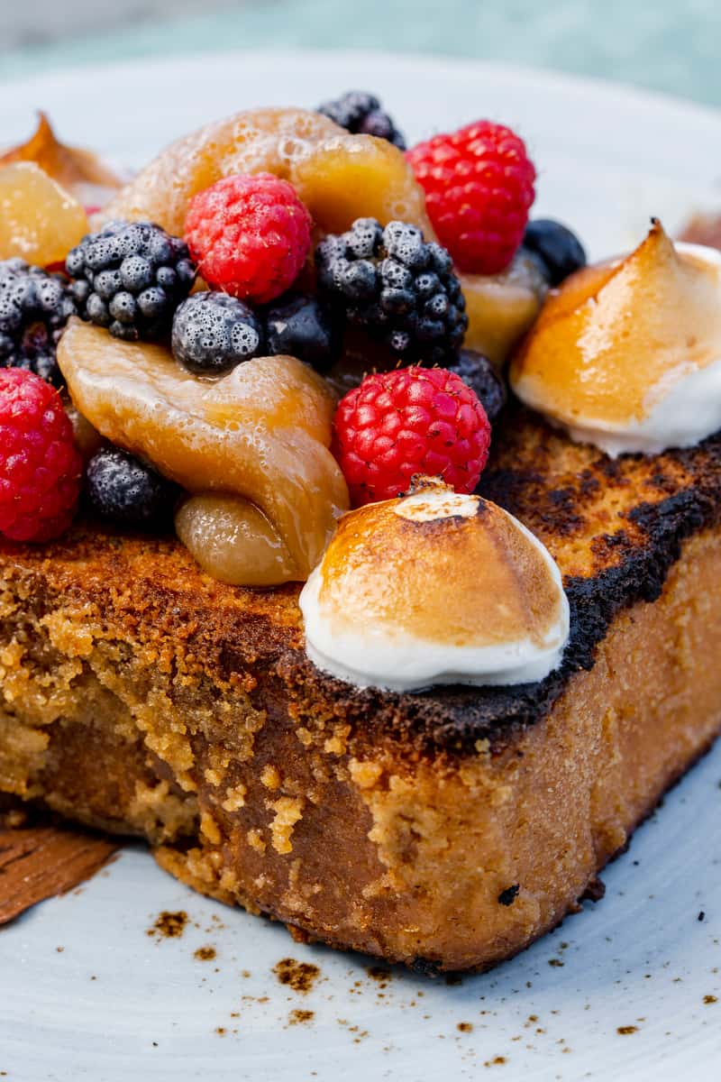 Divine French toast adorned with fresh berries, meringue, and delightful accompaniments, a heavenly brunch experience.