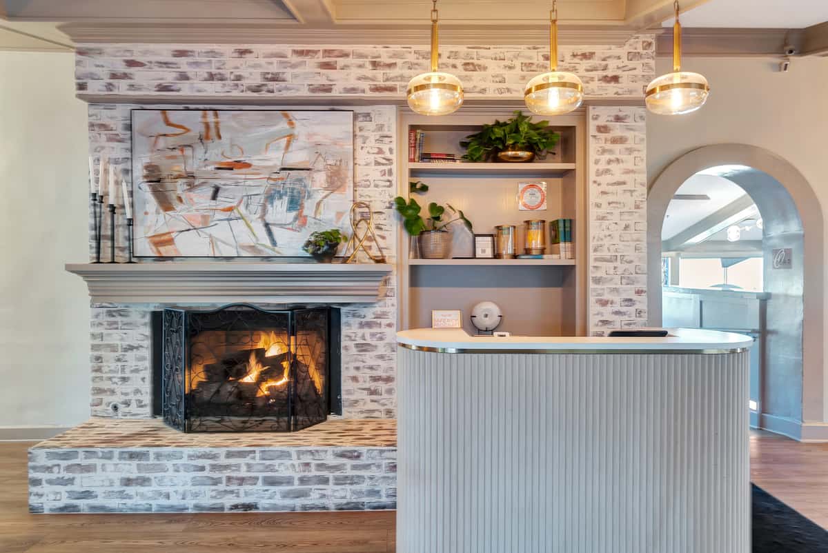 Ship lap wood hostess stand and a white-washed brick fireplace.