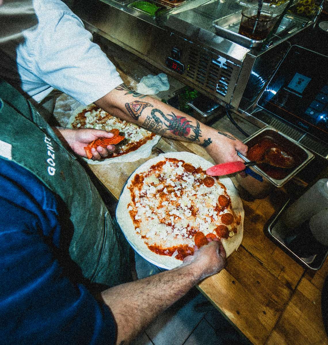 Chefs preparing pizza on a table
