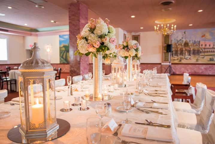 banquet table set with tall beautiful rose boquets