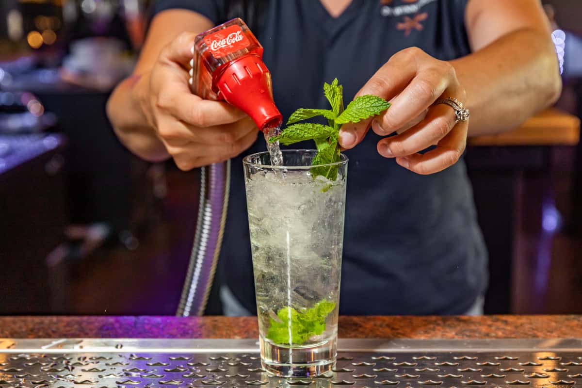 mint being added to a mojito