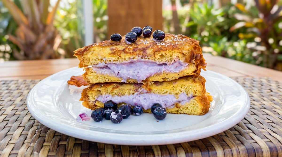 Blueberry stuffed French toast, dusted with powdered sugar and topped with fresh blueberries.