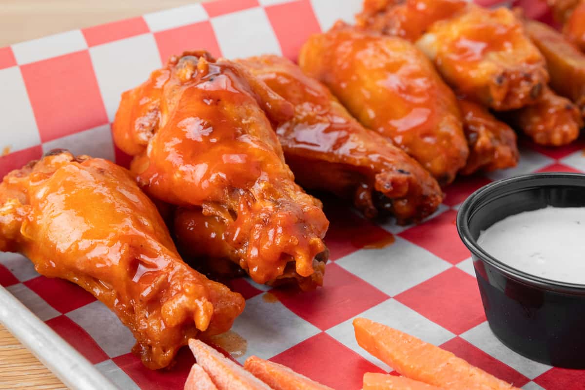 Buffalo chicken wings tossed in sauce and served with ranch dressing at North Georgia BBQ