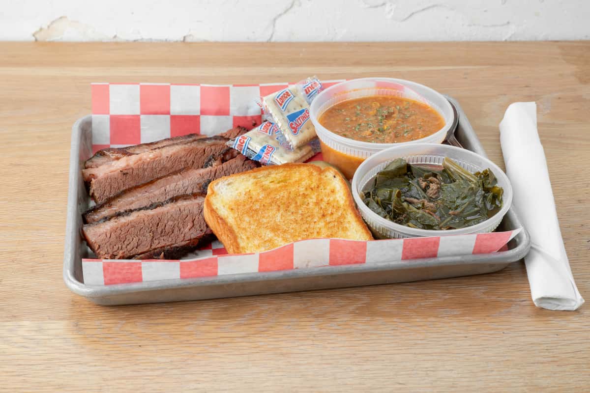 BBQ brisket plate with sliced smoked brisket, white bread, and sides served in a metal tray at North Georgia BBQ restaurant
