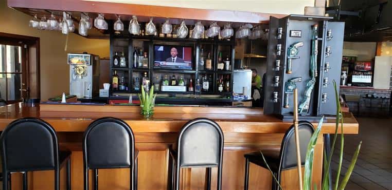 bar with bar stools and hanging wine glasses