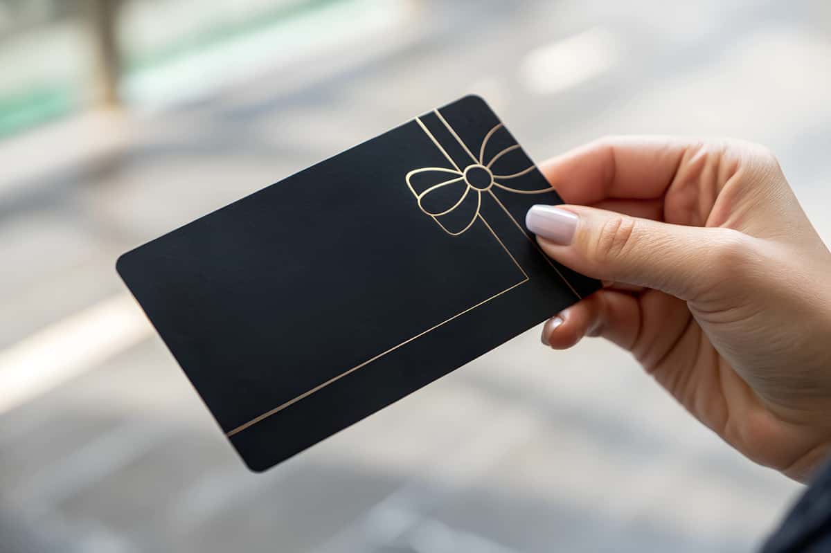 Woman holding a black gift card