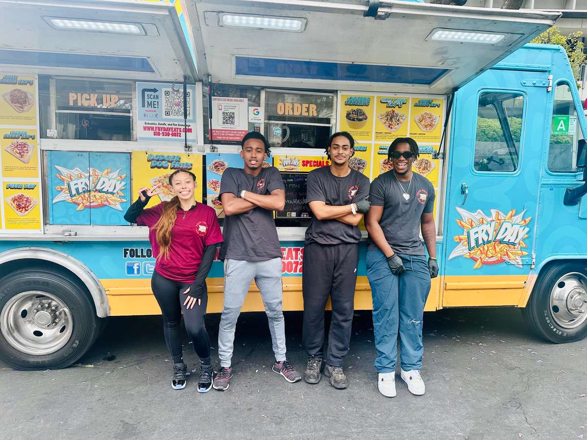 The FryDay food truck team standing proudly in front of the truck at a Los Angeles event