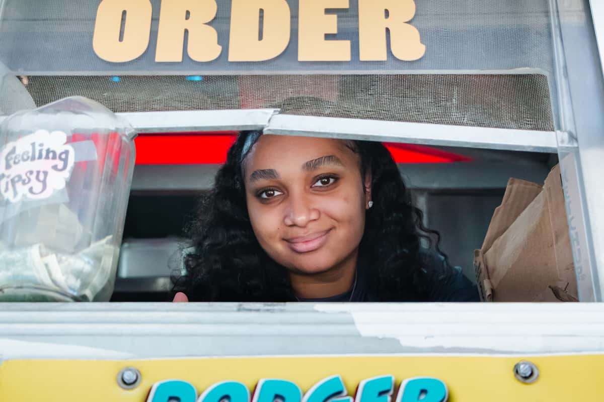 Hackathon catering in Los Angeles: a FryDay Food Truck team member serving loaded fries at the order window