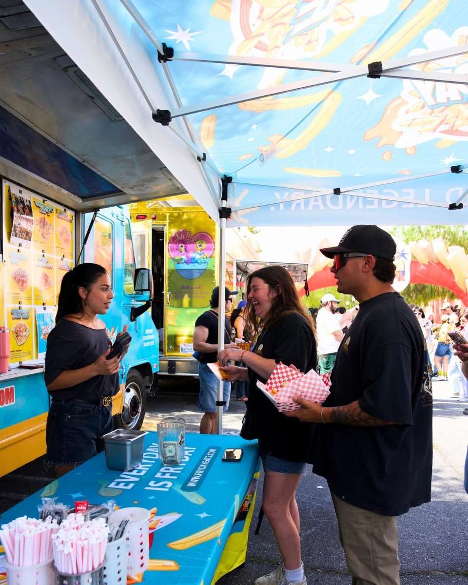 People gathered at the serving window of a colorful food truck