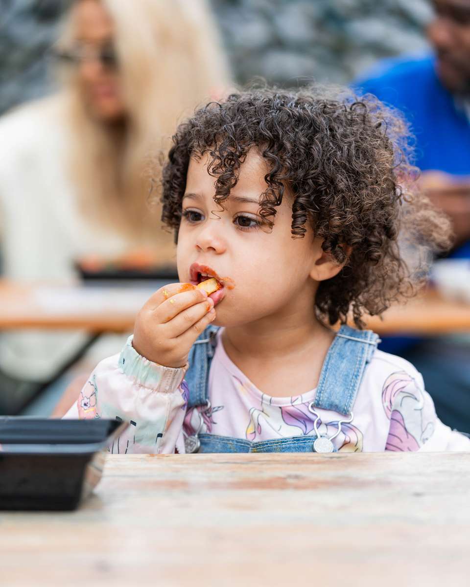 Young student enjoying FryDay loaded fries at a school event in Los Angeles